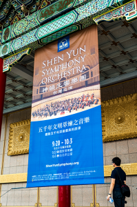 Gigantisks Shen Yun Symphony Orchestra plakāts pie Nacionālās koncertzāles Taipejā.
