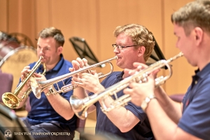 Principal trumpeter Eric Robins (L) works with his section.